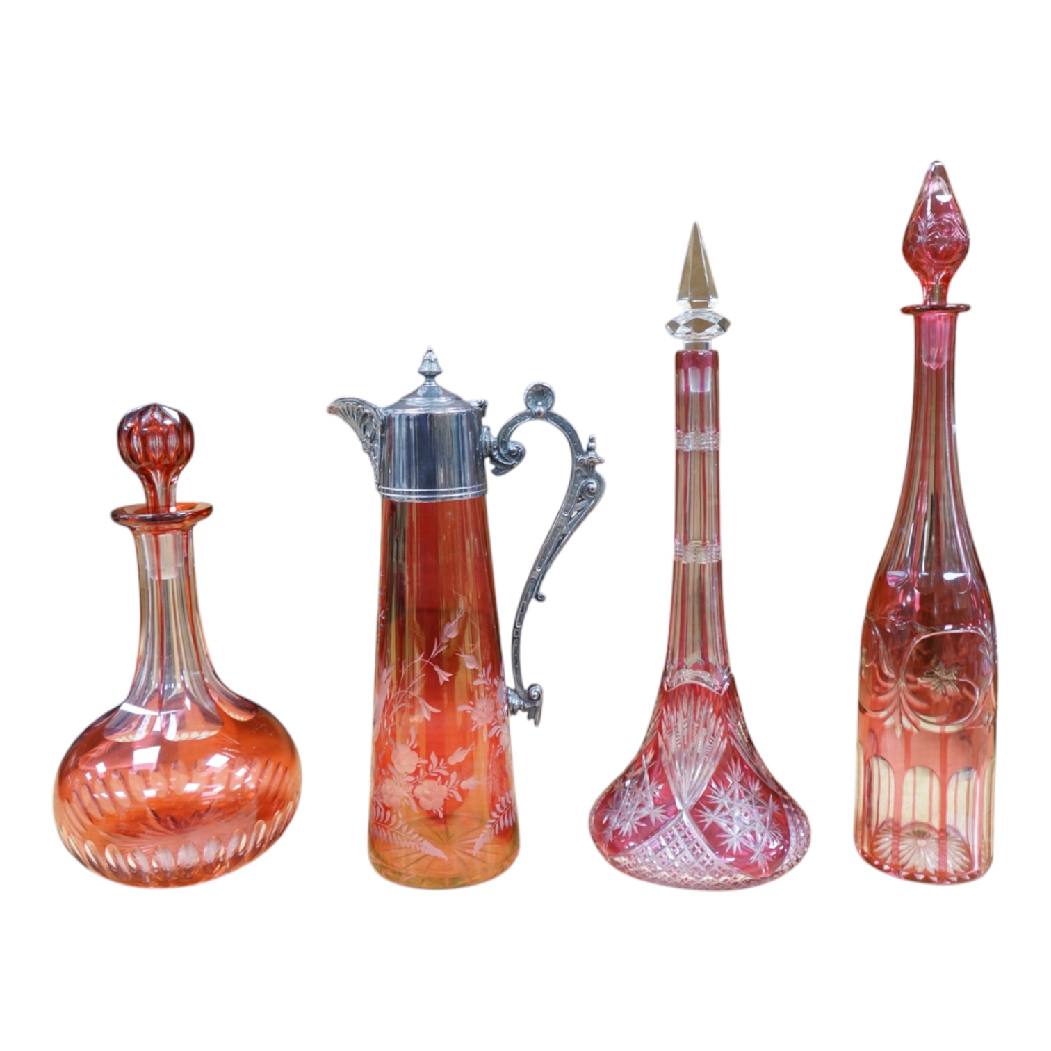 A collection of cranberry glassware comprising three decanters with stoppers and a silver plate mounted ewer, largest 41cm high. Condition - fair to good